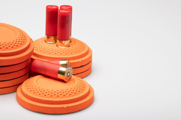 Clay shooting targets with shotgun shell bullets on white background