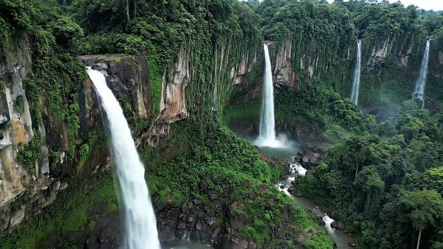 Multiple Waterfalls Cascading Through Lush Green Tropical Forest