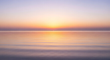 The sun rises over the ocean, casting a warm glow on the water and creating a beautiful and peaceful scene at the start of a new day