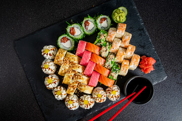 A vibrant selection of sushi rolls displayed artistically on a slate board