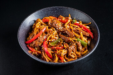 Delicious stir-fried noodles filled with vibrant peppers, tender beef, and topped with sesame seeds