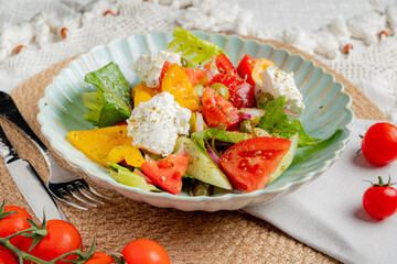 A vibrant salad combines fresh greens, ripe tomatoes, and creamy cheese, perfect for summer