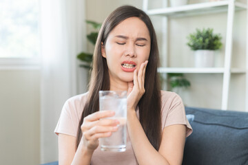 Suffering from toothache, hurt asian young woman touch cheek, face expression ache or feel pain,...