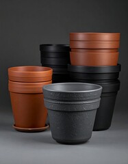 Assorted terracotta and dark-colored plant pots arranged on a gray background