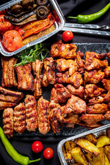 A vibrant collection of grilled meats, vegetables, and herbs displays a summer barbecue feast