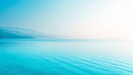 Obraz premium Tranquil turquoise water with distant misty mountains creating peaceful minimalist gradient composition in blue tones throughout.