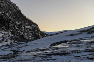 Landscape shot highlighting the rugged mountains and snow-covered beaches of arctic norway during a...