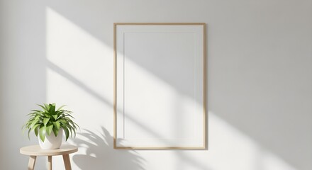 Blank poster frame mockup on textured wall with natural sunlight shadows and potted plant accent