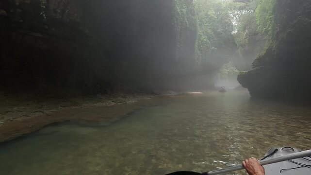 Tourist boat tour along mountain river in picturesque Martvili Canyon, sailing between rocky cliffs in gorge