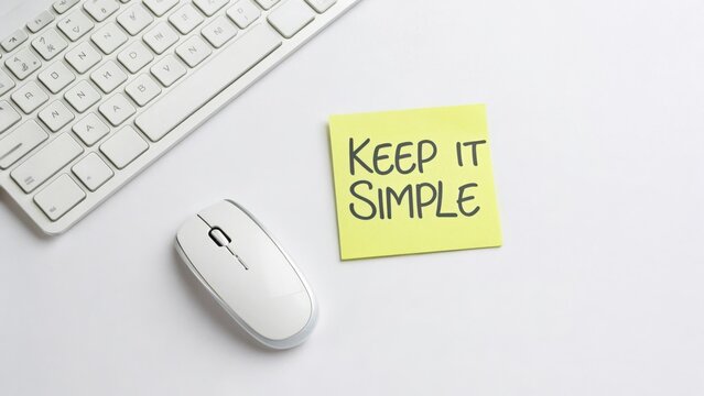 White Computer Mouse and Keyboard with a Yellow Sticky Note that Says Keep It Simple on a Light Background - Powered by Adobe