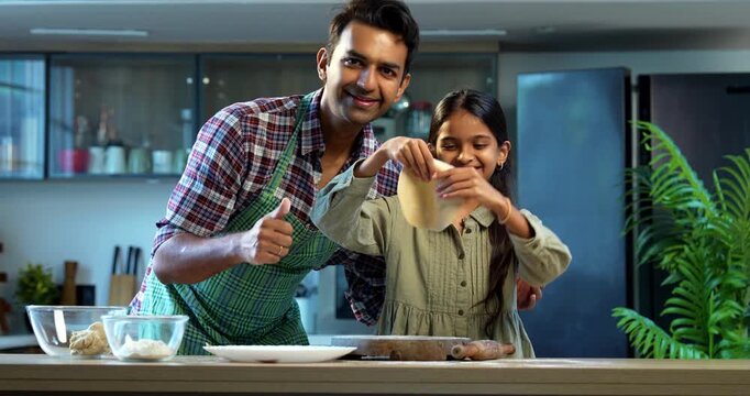 Making chapati together, Indian father and daughter bonding in modern kitchen, Asian dad teaching young girl cooking, family quality time at home, child helping parent with food preparation