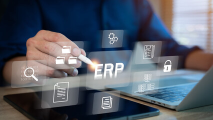 ERP document management concept. Businessman working on laptop computer with icons on virtual screen.