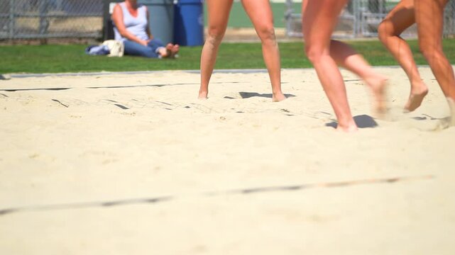 athletes feet in sand playing volleyball