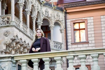 Beautiful woman photographer in front of a fairy-tale historic castle in Poland