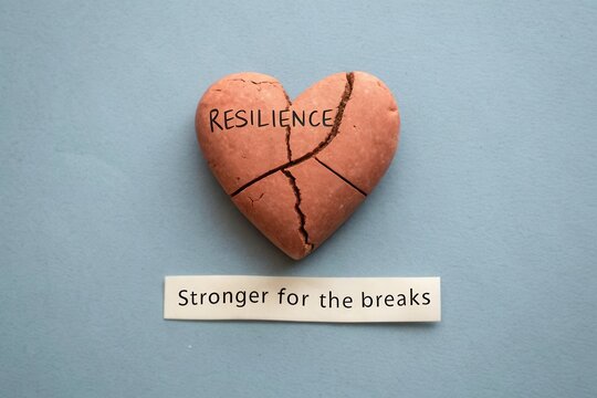Heart Shape Cookie with Inscription Resilience and Text Stronger for the Breaks on Light Blue Background