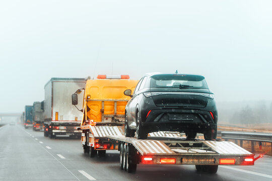 Fototapeta Flatbed towing service transporting a car