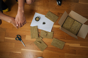 Gardener preparing rockwool cubes for seed starting in hydroponic tower garden, emphasizing sustainable agriculture and home gardening practices for healthy, fresh produce. Concept of urban farming.