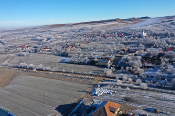 Aerial view of a misty countryside village, in early morning lights