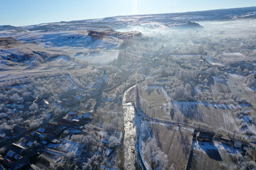 Aerial view of a misty countryside village, in early morning lights