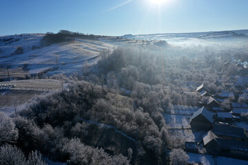 Aerial view of a misty countryside village, in early morning lights