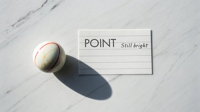 White card with text POINT and Still bright laying next to a round ball on a marble surface creating a stylish composition