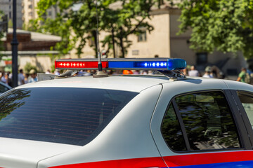 police car with lights on city street during daytime