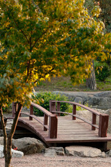 Obraz premium natural vertical landscape decorative environment space spring season of small red wooden bridge across pond with trees and rocks objects