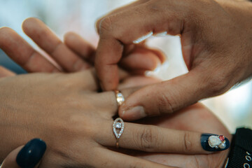 two hands of a man and a woman exchanging rings