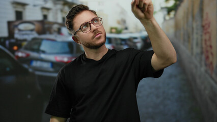 Young man with beard gives thumbs up on busy city street in the afternoon, showcasing a positive...