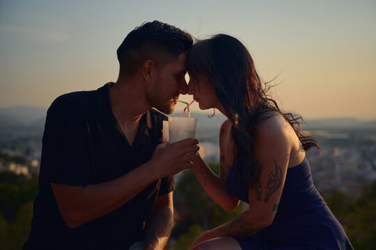 Couple sharing a drink at sunset, intimacy concept