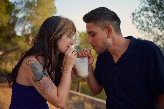 Couple sharing milkshake, enjoying a romantic date