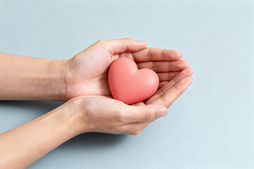 Hands holding pink heart shape
