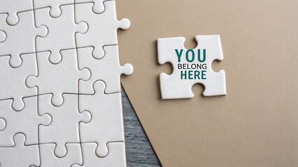 Obraz premium Puzzle Piece with You Belong Here Text on Light Background Representing Connection and Inclusion in Community or Team