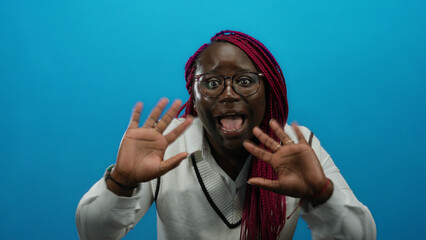 Woman communicating with expressive gestures against vibrant blue background, emphasizing...