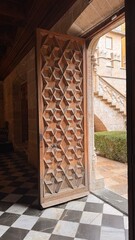 Doorway to History: An aged, elaborately carved door stands ajar, revealing a glimpse into an elegant hallway, with details that speak to timeless architectural beauty and rich history.