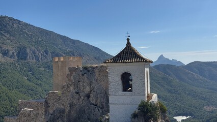 Ancient Fortress Against Mountainous Backdrop: A captivating scene unfolds, with a historic fortress standing proudly against the backdrop of majestic mountains and a serene sky.