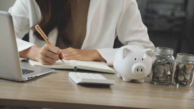 rAsian woman hand put coins in piggy bank,Saving money wealth and financial concept.