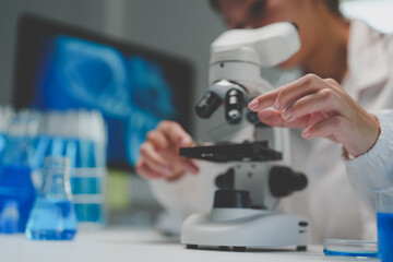Scientist analyzing sample using microscope in laboratory