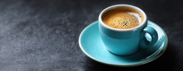 The coffee cup in a turquoise saucer on a moody dark surface