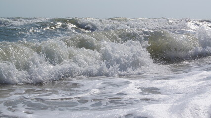 Fototapeta premium Storm at sea. Foaming seawater from raging waves. A dangerous storm at sea. A beautiful and dangerous element. 
