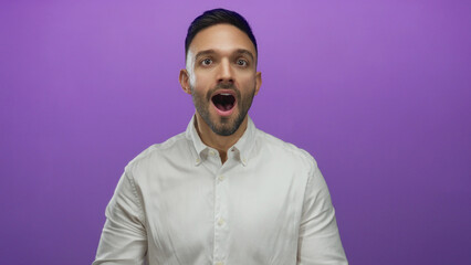 Young hispanic man expressing various emotions against a vibrant purple background, showcasing a range of facial expressions and gestures in a white shirt.