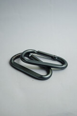 Macro shot of two matte grey carabiners showing details of the metal texture. Industrial hardware concept.