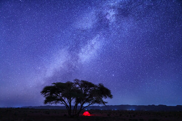 Lone tent glows under a starry desert sky © Jeroen Kleiberg