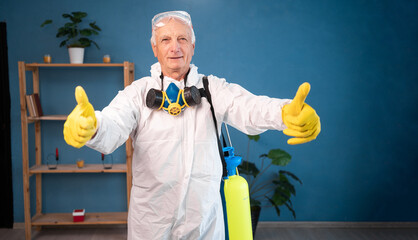 portrait of Elderly pest control worker killing insects inside infested house holding thumbs-up in...