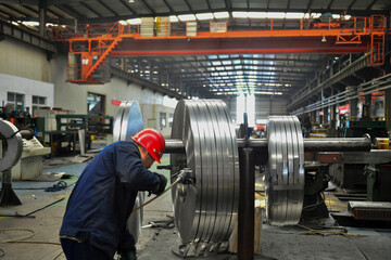 Workers on the production line of the strip steel coil factory are working