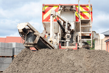 Mixer truck delivered concrete on construction site and unloaded on ground