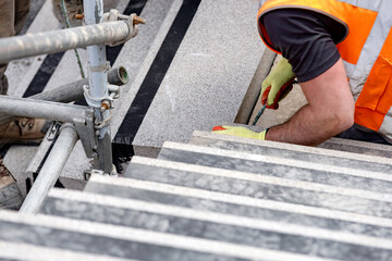 Builders working on construction site to install concrete blocks on stairs to perfect levels according to tolerances