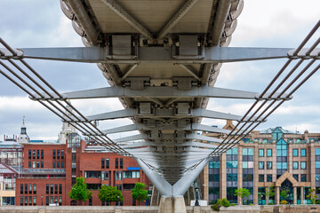 Under the Milennium Bridge, London, United Kingdom. Steel suspension bridge for pedestrians crossing the River Thames in London, England, linking Bankside with the City of London.