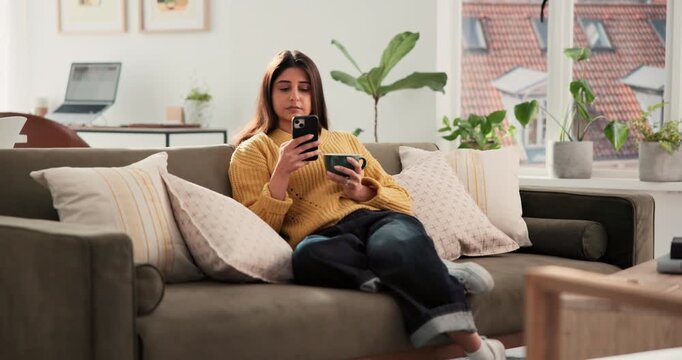 Woman, phone and coffee on sofa with thinking, texting and relax with online dating in living room. Person, smartphone and tea cup on couch, mobile app and decision with social media at apartment
