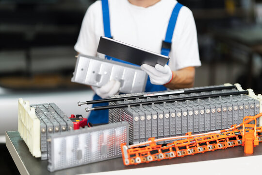 Serviceman repairing electric vehicle battery pack in workshop